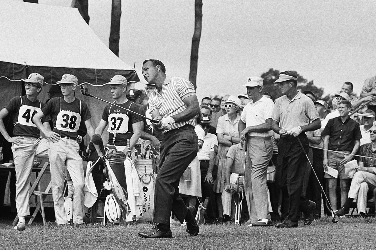 Arnold Palmer Ligonier, Pa., winner of the U.S. Open golf championship in 1960, watches flight of his tee shot on first hole at The Country Club, June 20, 1963 in Brookline, Mass., at start of the 1963 USGA Open. Playing in threesome with Palmer are Jay Hebert, right, of Lafayette, La., and Doug Ford of Brookville, N.Y. (AP Photo)